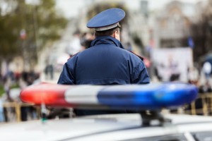 Crime law security service officer cop guarding street near police car with siren light