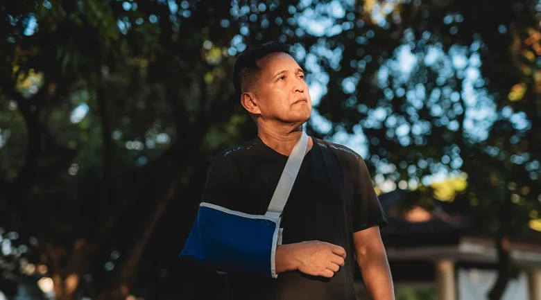 A man looking up with his arm in a cast after an accident.