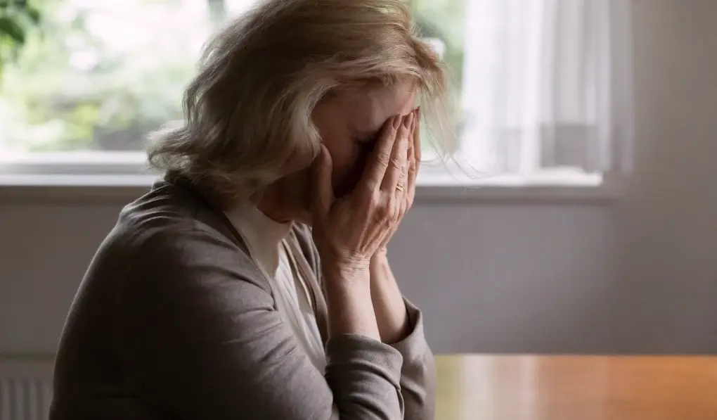 A woman covering her face and crying