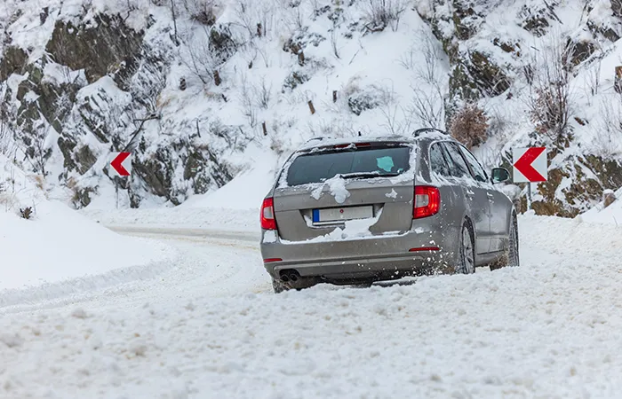 Car on the snowy mountain road during severe conditions.