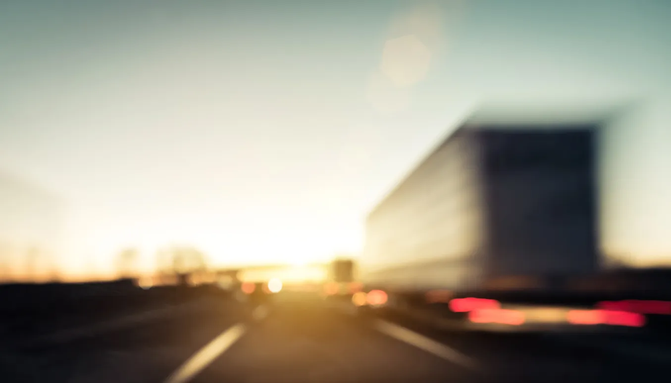 An abstract, blurry photograph taken from a vehicle's perspective.