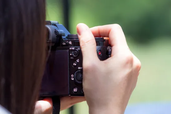 Person adjusting a dial on a camera.