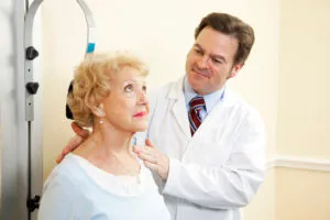 Chiropractor examines an older woman's neck.