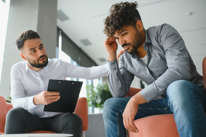 Psychologist supporting upset arab patient during therapy session, addressing post traumatic stress disorder and providing mental health care